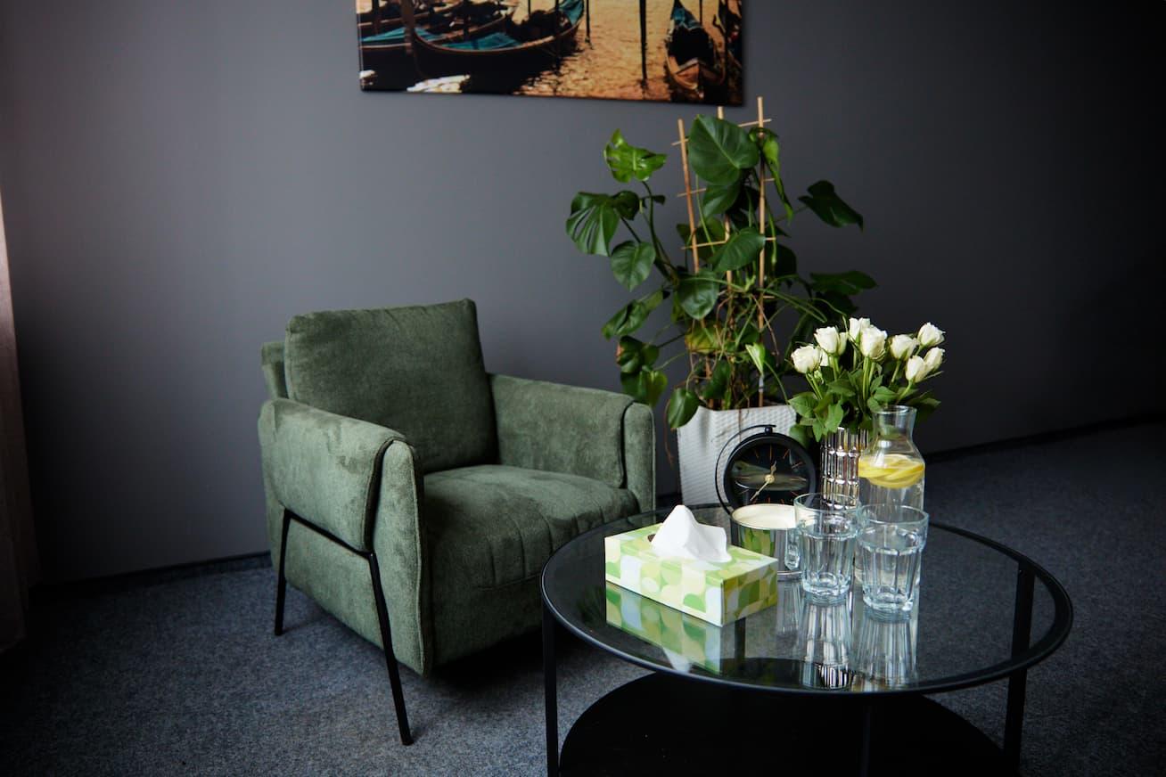 Gabinet terapeutyczny z fotelem i ozdobnym stołem z kwiatami